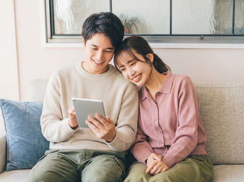 寄り添いながら一緒に画面を見る男女